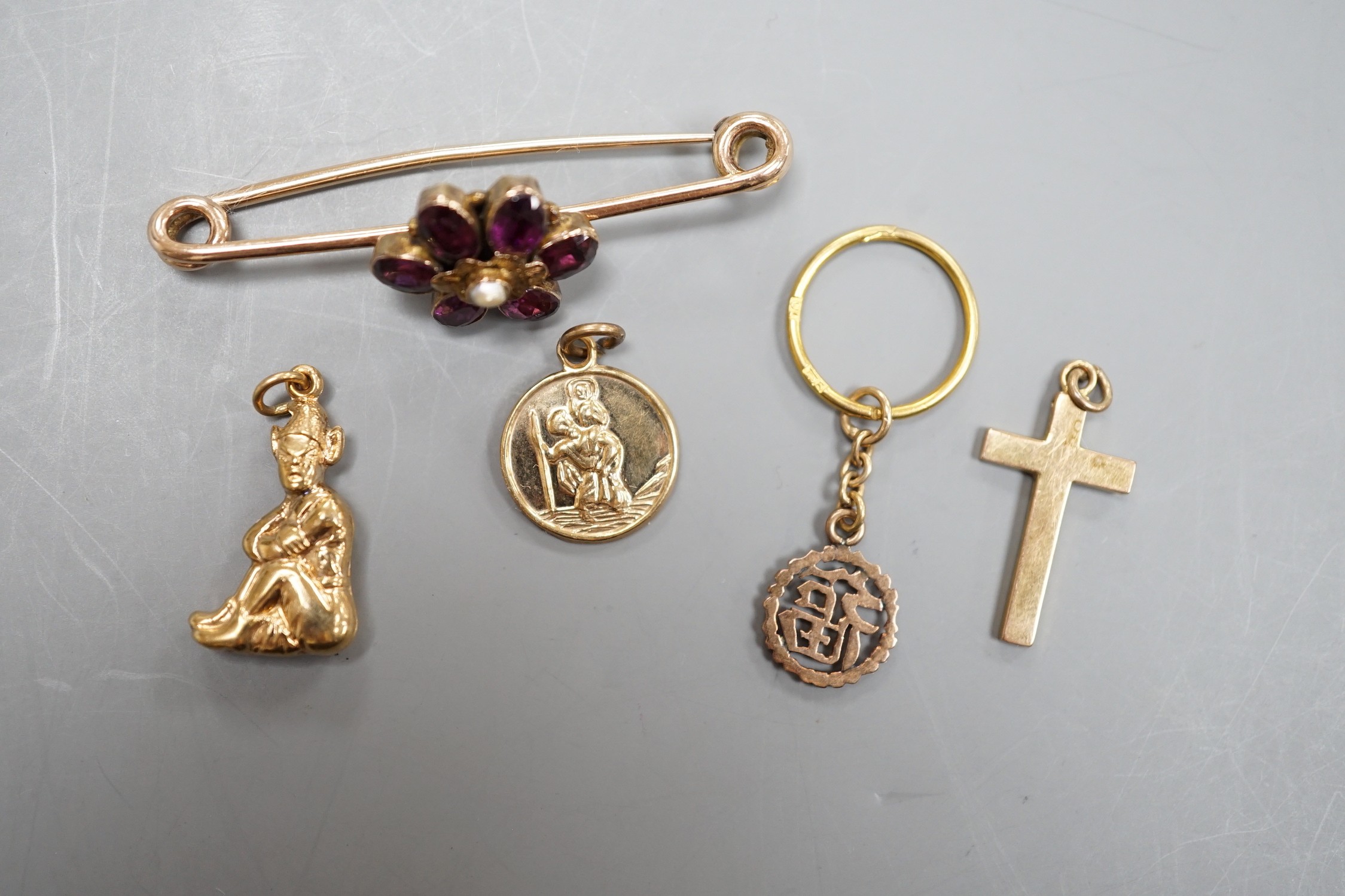 An early 20th century yellow metal, garnet and seed pearl cluster set bar brooch (converted ring?), 44mm and four assorted charms including three 9ct, gross weight 7 grams.